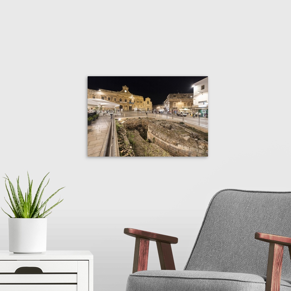 A modern room featuring Night view of the Town Hall and ancient ruins in the medieval old town of Ostuni, Province of Bri...