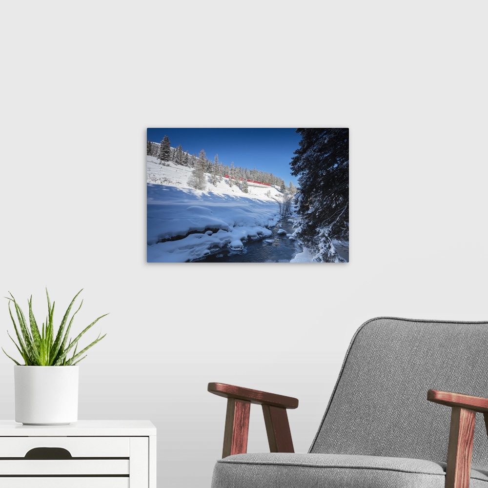 A modern room featuring Rhaetian Railway on the Chapella Viadukt surrounded by snowy woods, Canton of Graubunde, Engadine...