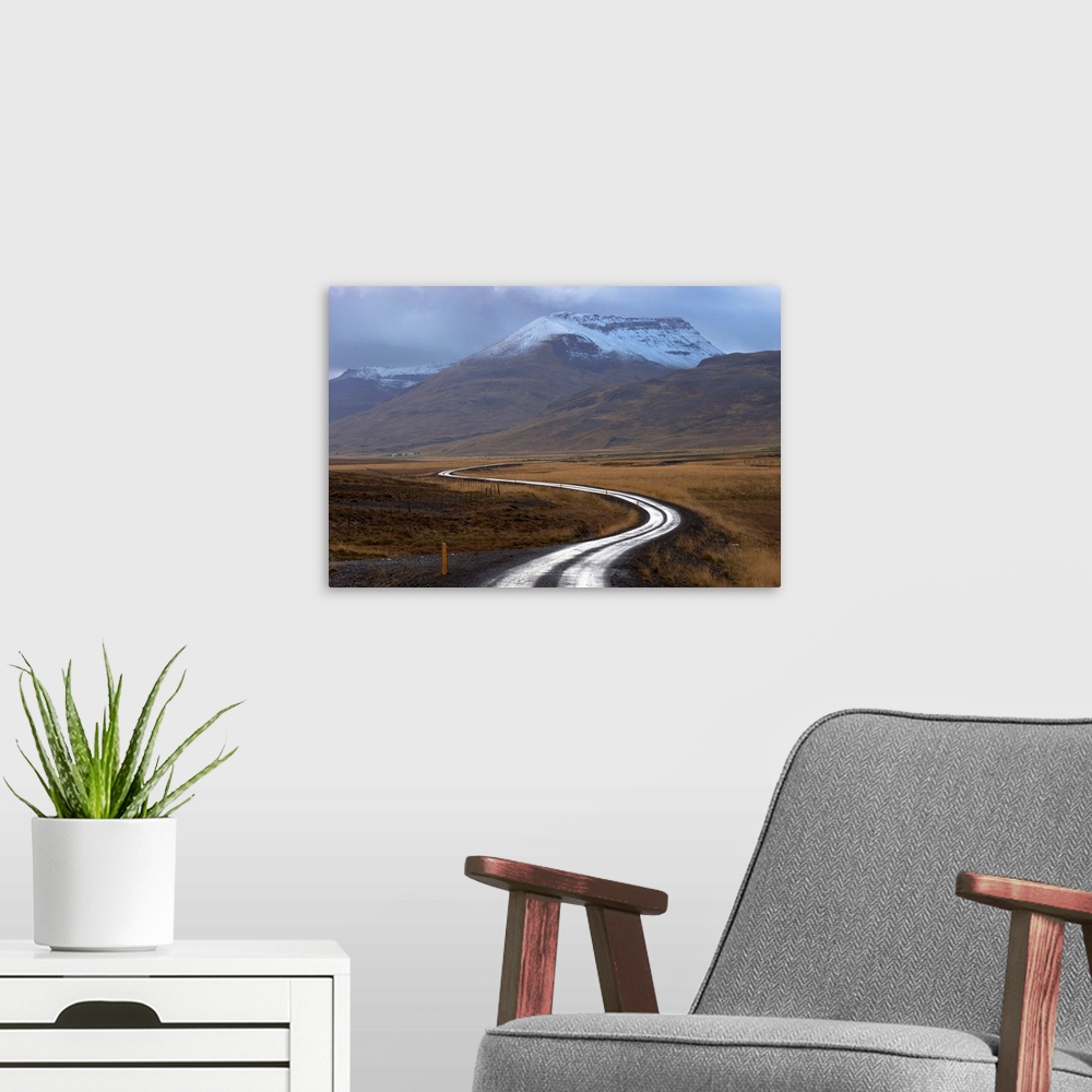A modern room featuring Road and landscape in Vatsnes Peninsula, with snow-covered mountains in October, north coast of I...