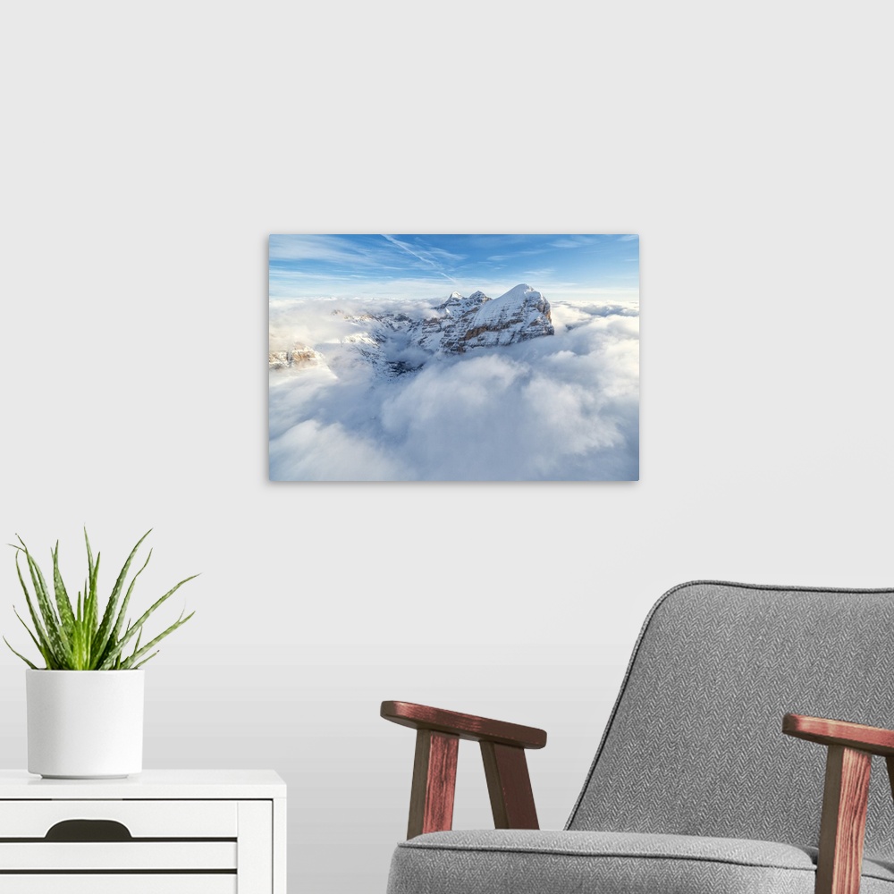 A modern room featuring Aerial view of the snow capped Tofane group in a sea of clouds, Dolomites, Belluno province, Vene...