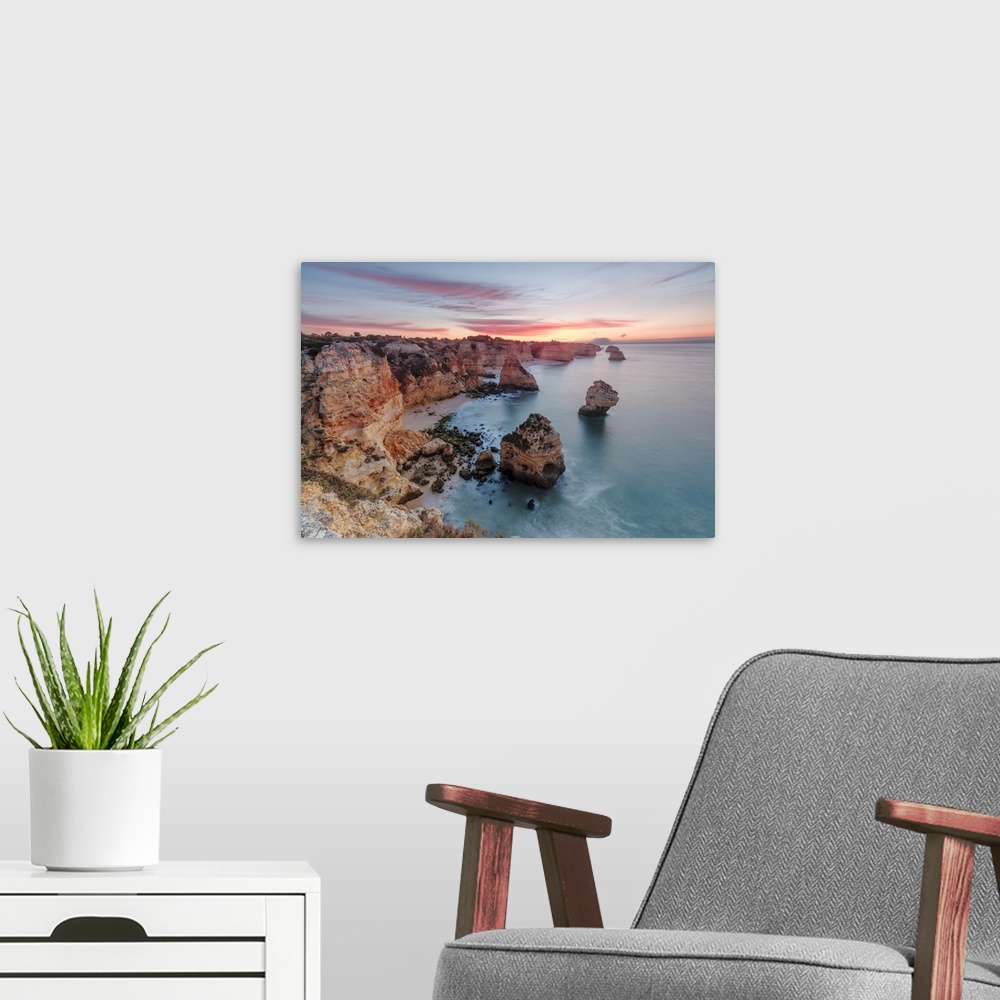 A modern room featuring Sunrise on cliffs framed by turquoise water of the ocean, Praia da Marinha, Caramujeira, Lagoa Mu...