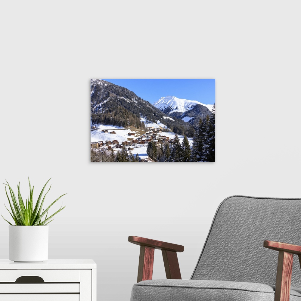 A modern room featuring The alpine village of Langwies framed by woods and snowy peaks, district of Plessur, Canton of Gr...