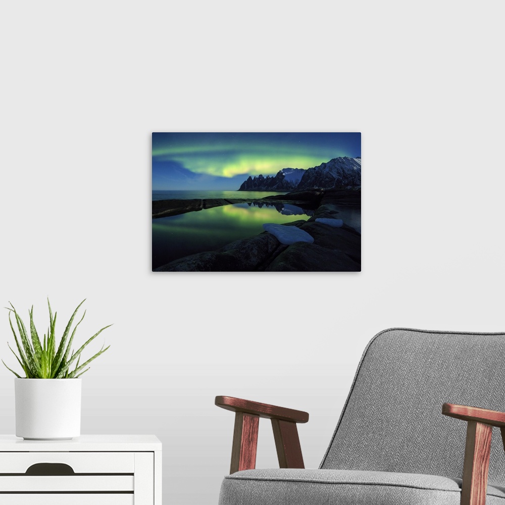 A modern room featuring The Northern Lights (aurora borealis) and stars reflected in the icy sea, Tungeneset, Senja, Trom...