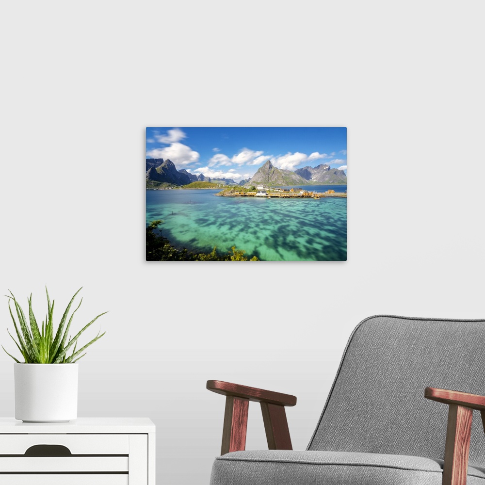 A modern room featuring The turquoise sea frames the typical fishing village surrounded by rocky peaks, Sakrisoy, Reine, ...