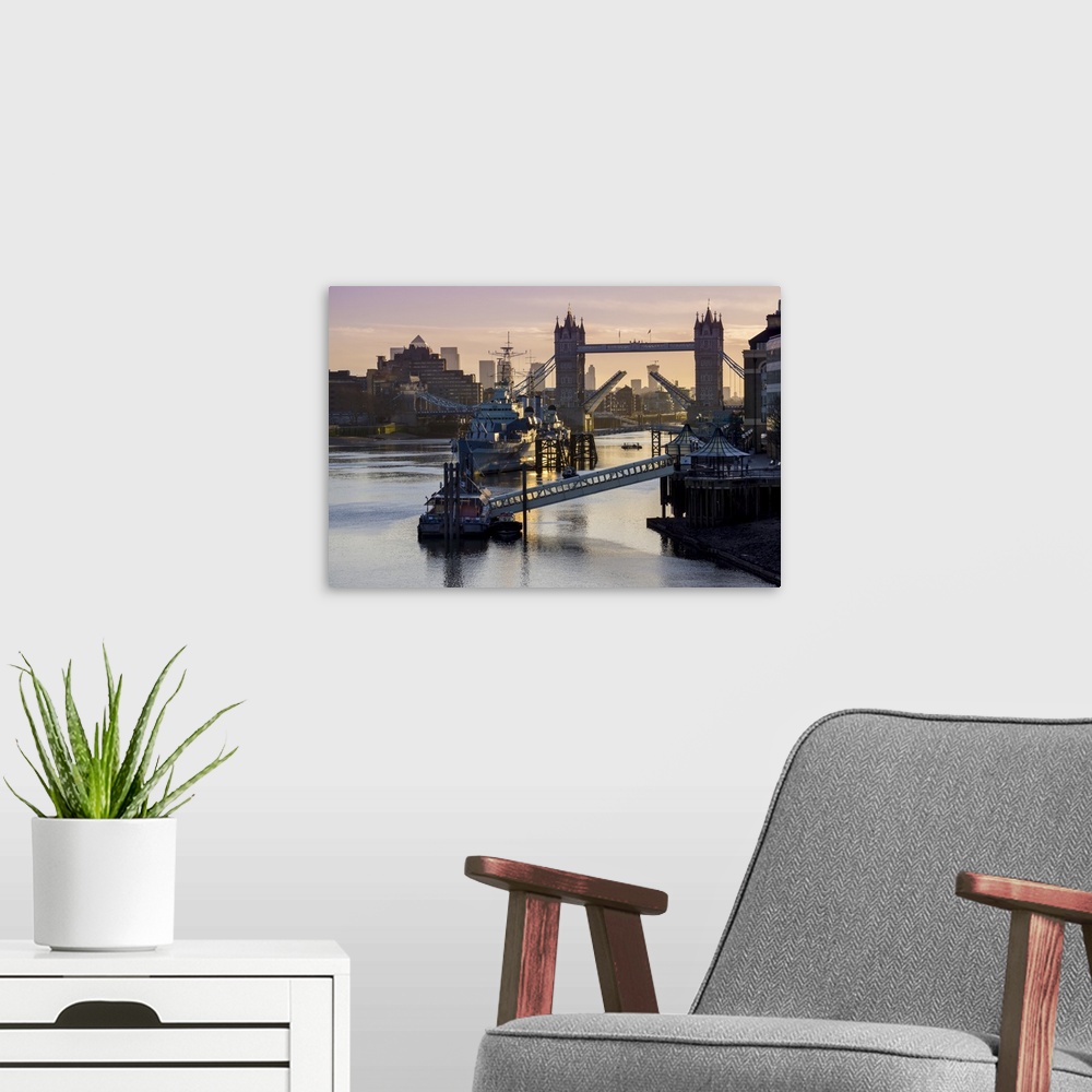 A modern room featuring Tower Bridge raising deck with HMS Belfast on the River Thames, London, England