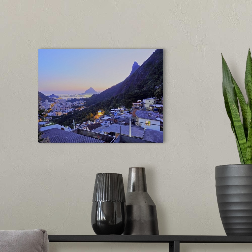 A modern room featuring Twilight view of the Favela Santa Marta with Corcovado and the Christ statue behind, Rio de Janei...
