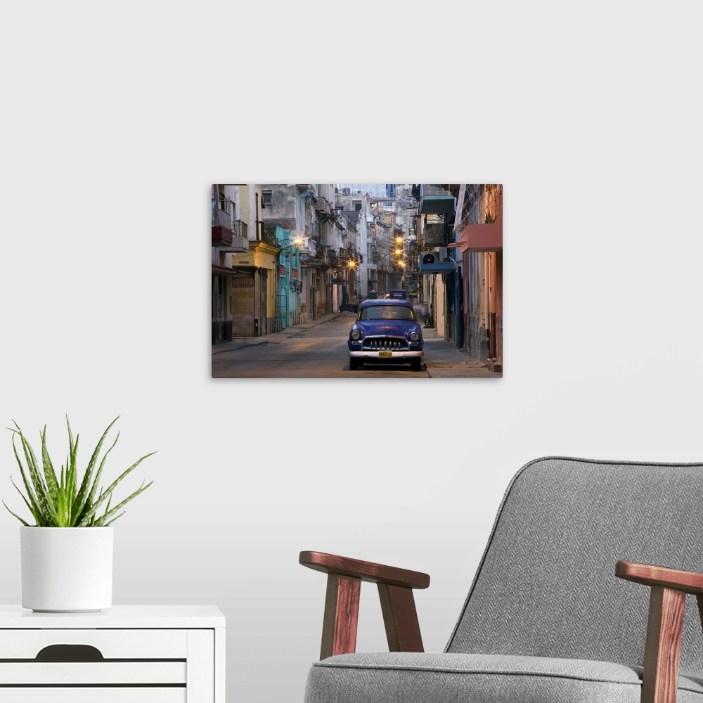 A modern room featuring View along quiet street at dawn showing old American car, Havana, Cuba