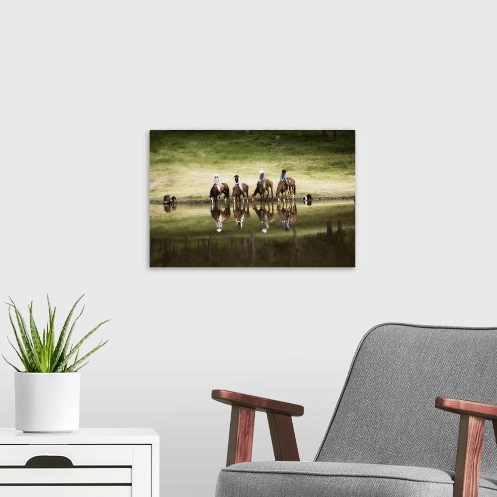 A modern room featuring Photograph of horseback riders and their dogs by water at dusk.  The riders and horses and reflec...