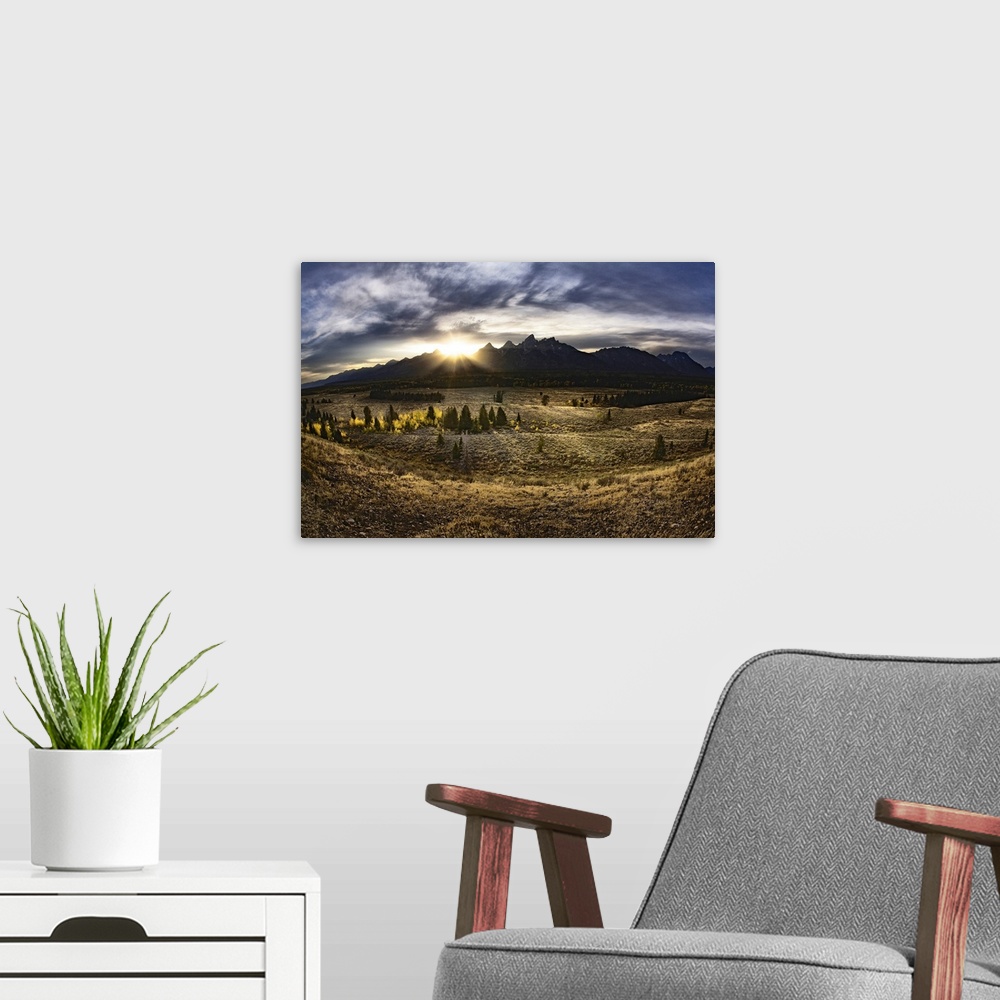 A modern room featuring Giant, landscape photograph of a vast field in Jackson Hole, Wyoming, the sun rising just above t...