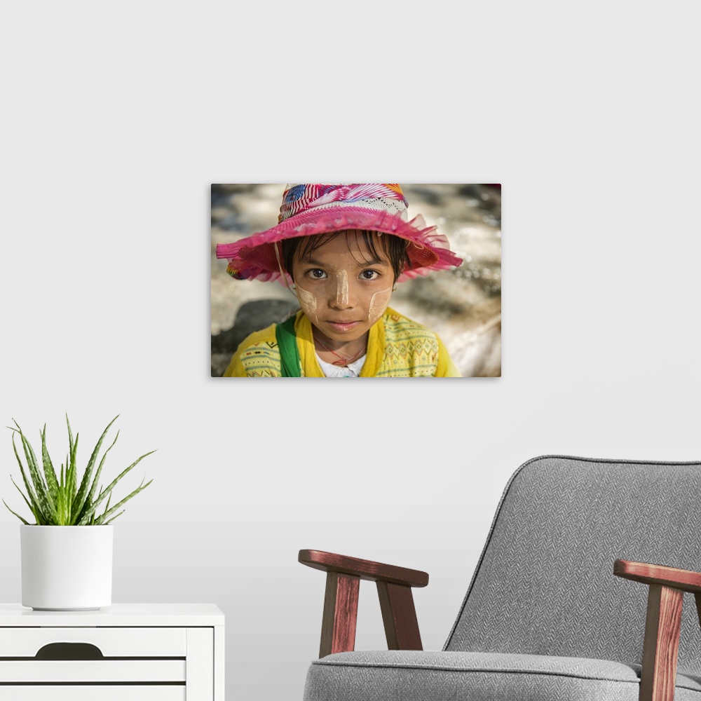 A modern room featuring Young Burmese girl with Tanaka face paint