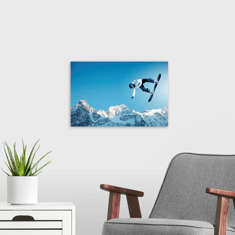 A modern room featuring Snowboarder making jump high in clear sky, with mountains in the background.