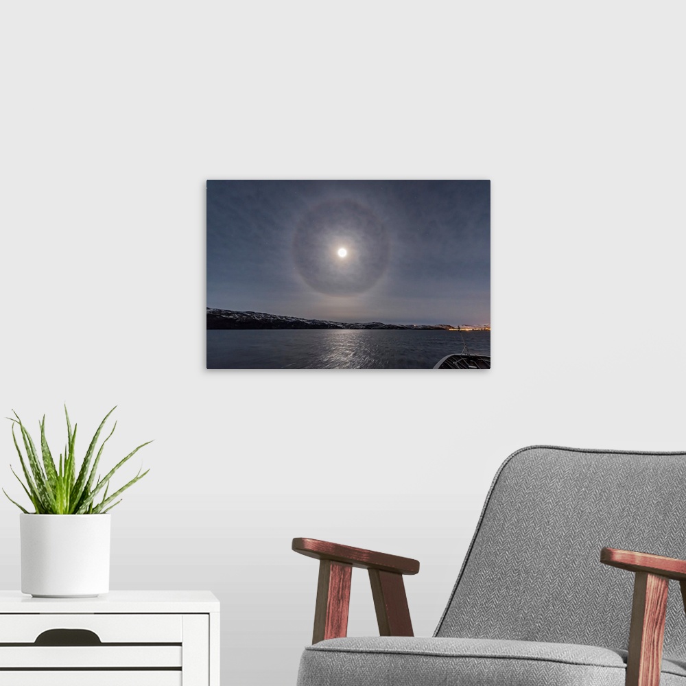 A modern room featuring A halo around the nearly full moon over the Barents Sea in northern Norway.