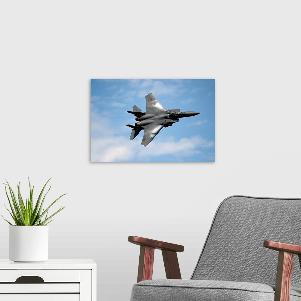 A modern room featuring An F-15E Strike Eagle soars through the sky.