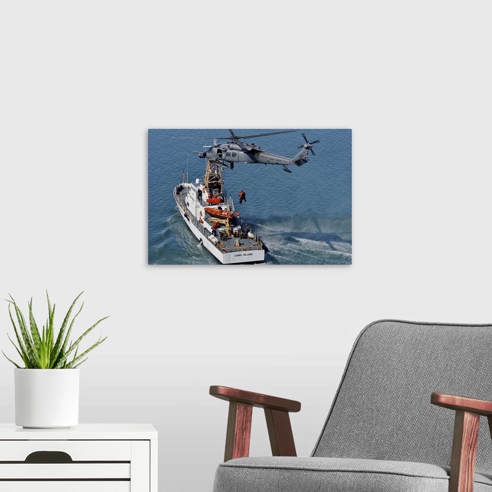 A modern room featuring An HH-60G Pave Hawk performs a hoist over U.S. Coast Guard Cutter Long Island.