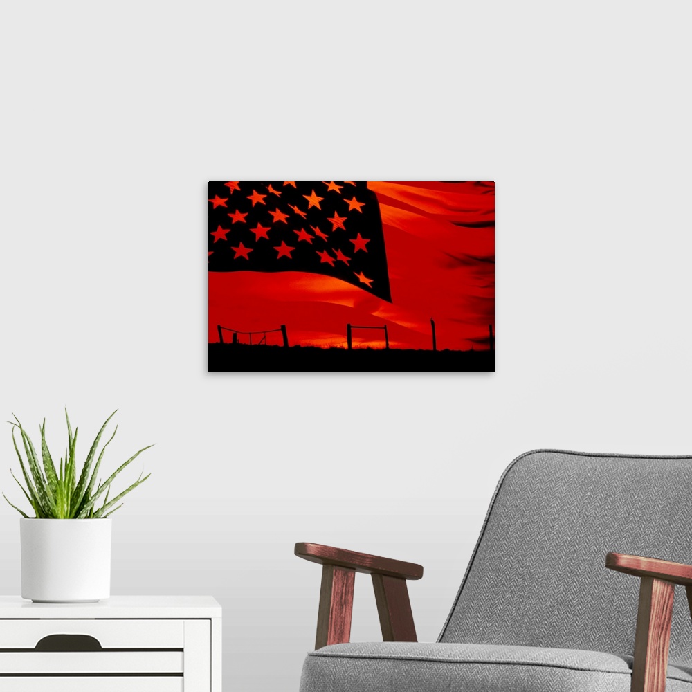 A modern room featuring Huge photograph displays a broken fence in a desolate field as the sun begins to set.  Photograph...