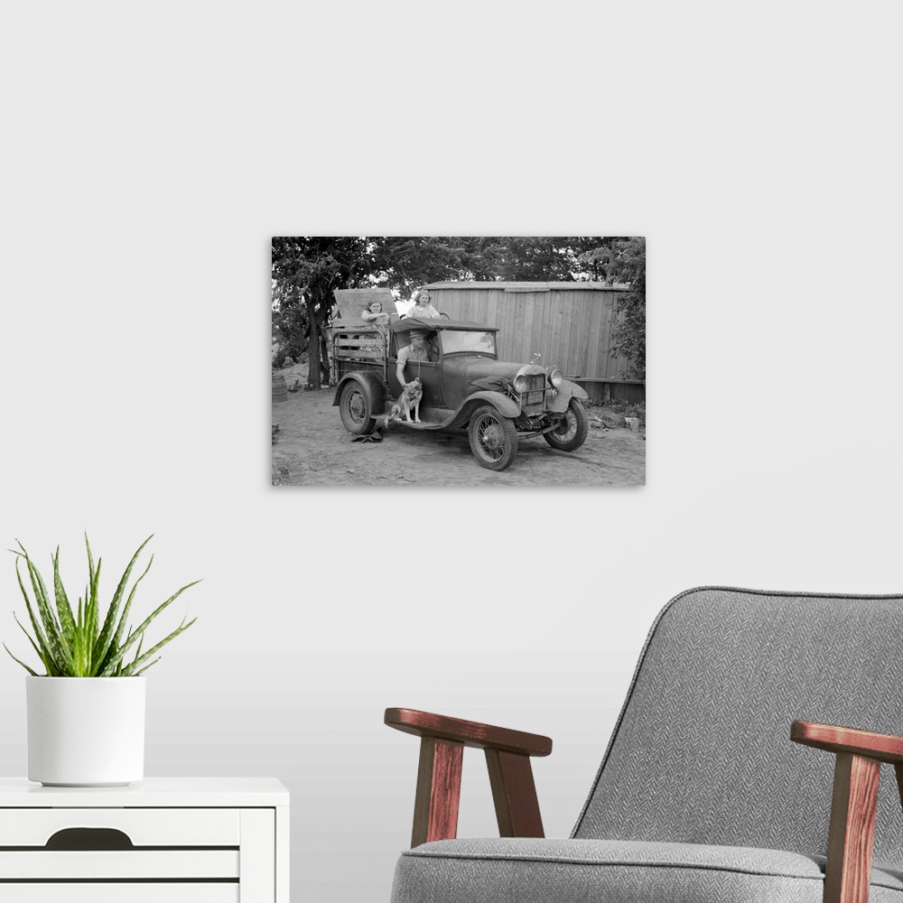 A modern room featuring Great Depression era photograph of a migrant family in a packed car preparing to leave.
