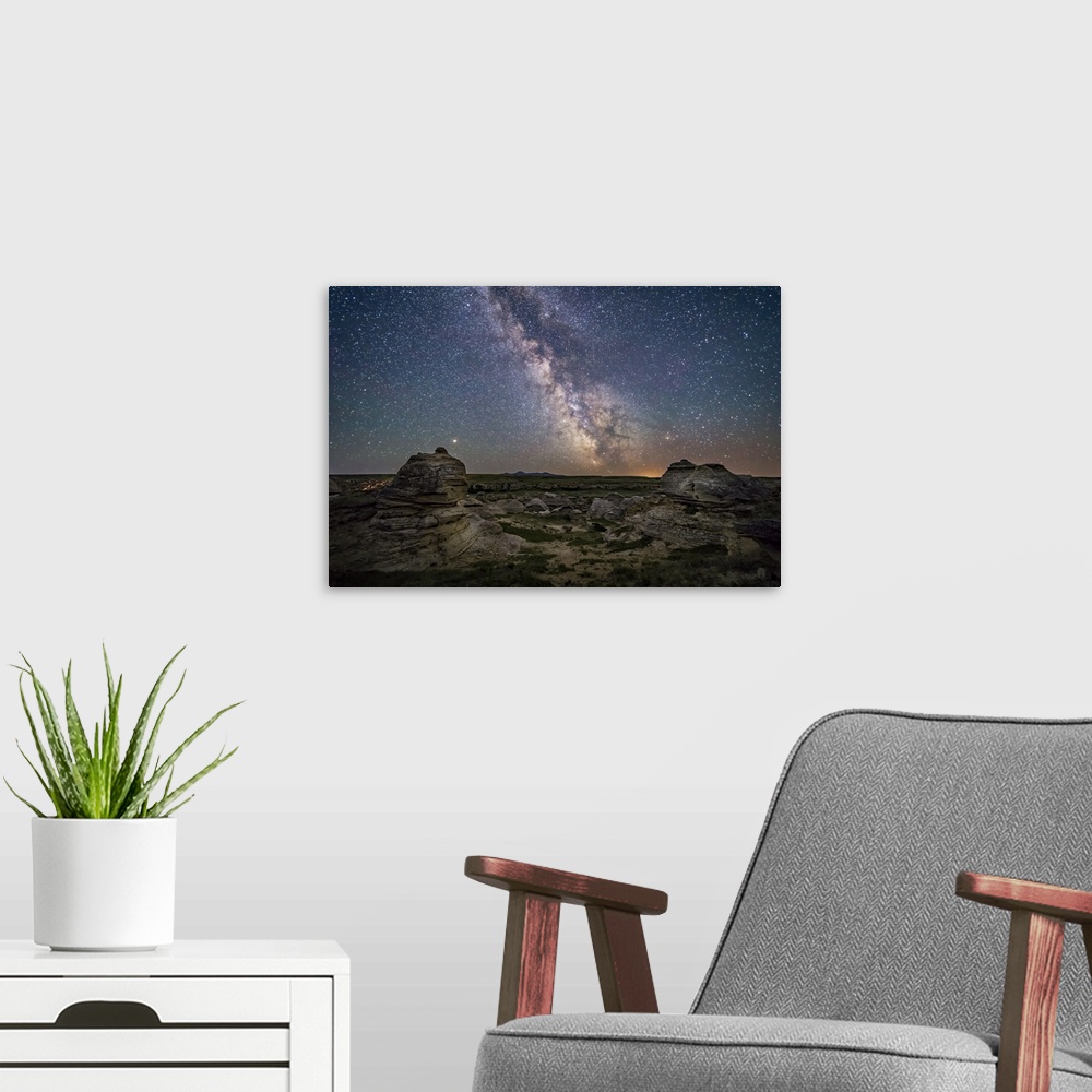 A modern room featuring Mars and the galactic center of Milky Way over Writing-on-Stone Provincial Park, Canada.