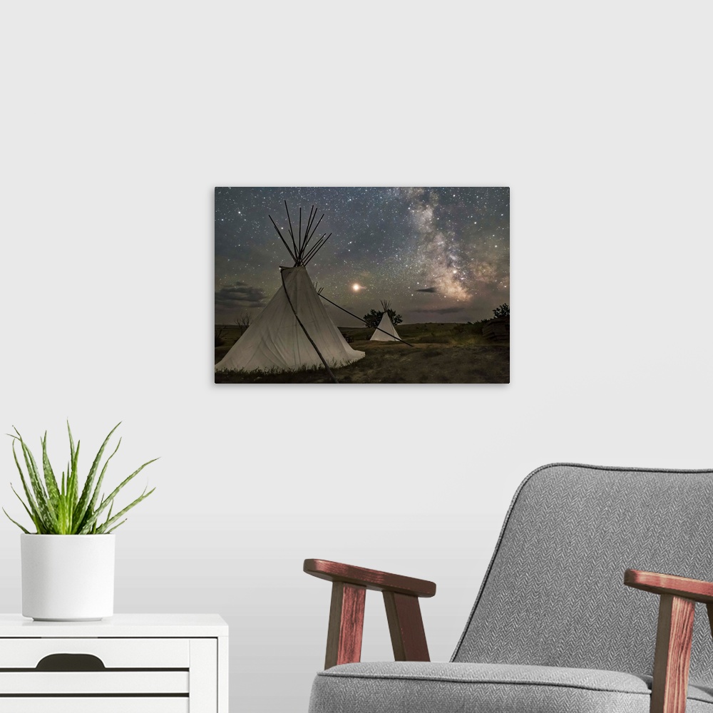 A modern room featuring Mars and the Milky Way over the tipis in Grasslands National Park, Saskatchewan, Canada.