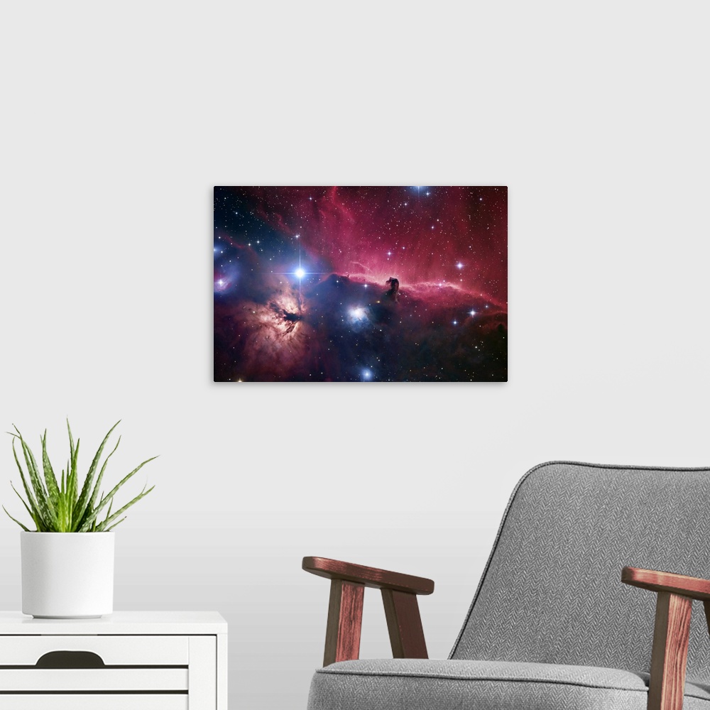 A modern room featuring Large photograph displays an open part of space filled with stars and focusing on aodark cloud of...