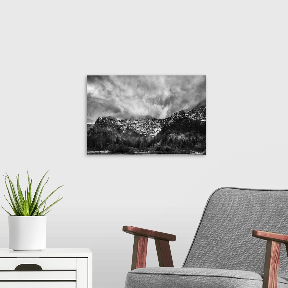 A modern room featuring A black and white photograph of snow cover mountains and a heavy clouded sky.