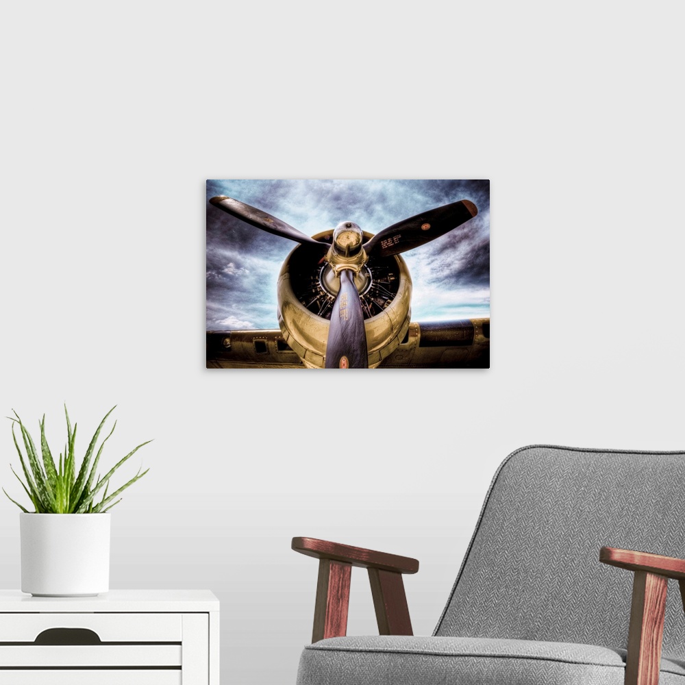 A modern room featuring Front view photograph of vintage airplane with a dark cloudy sky in the background.