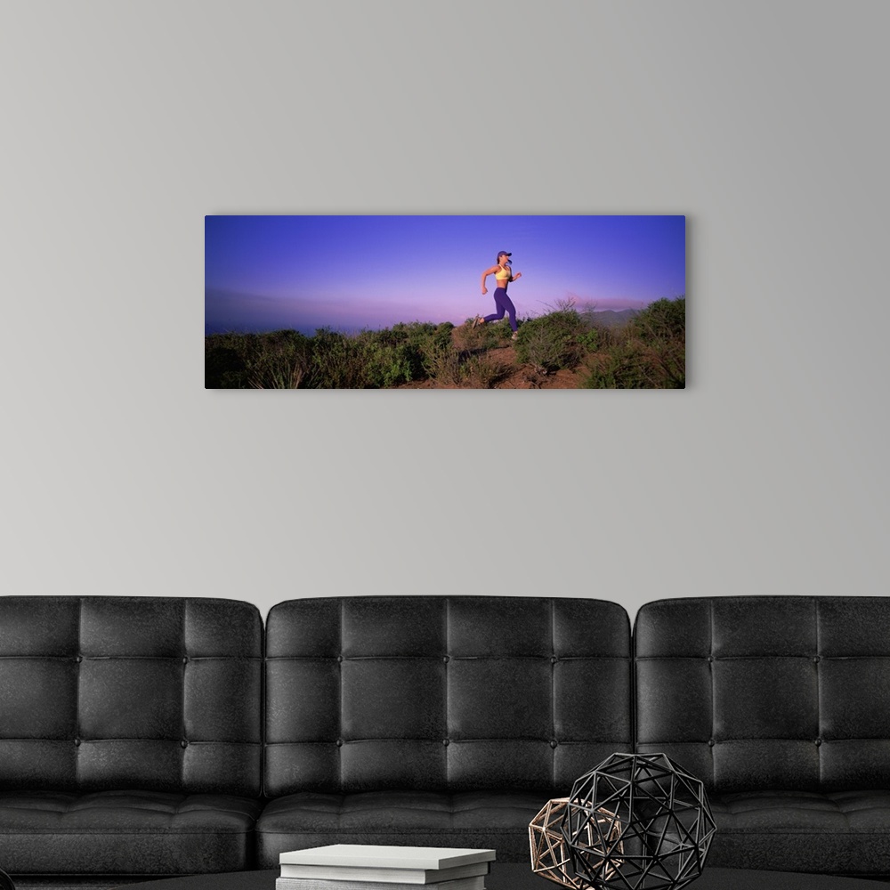 A modern room featuring Side profile of a young woman running on a hill