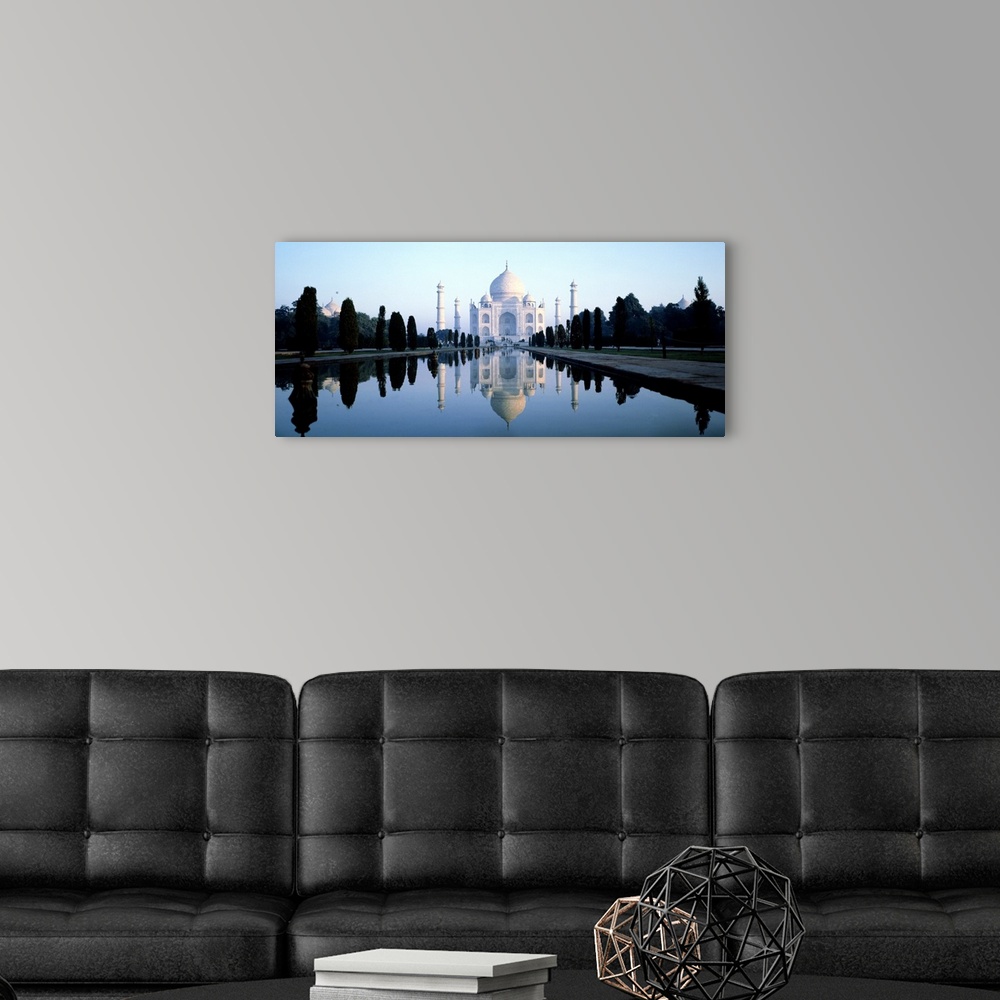A modern room featuring Landscape photograph on a large wall hanging of 17th-century Taj Mahal reflecting in the water, s...