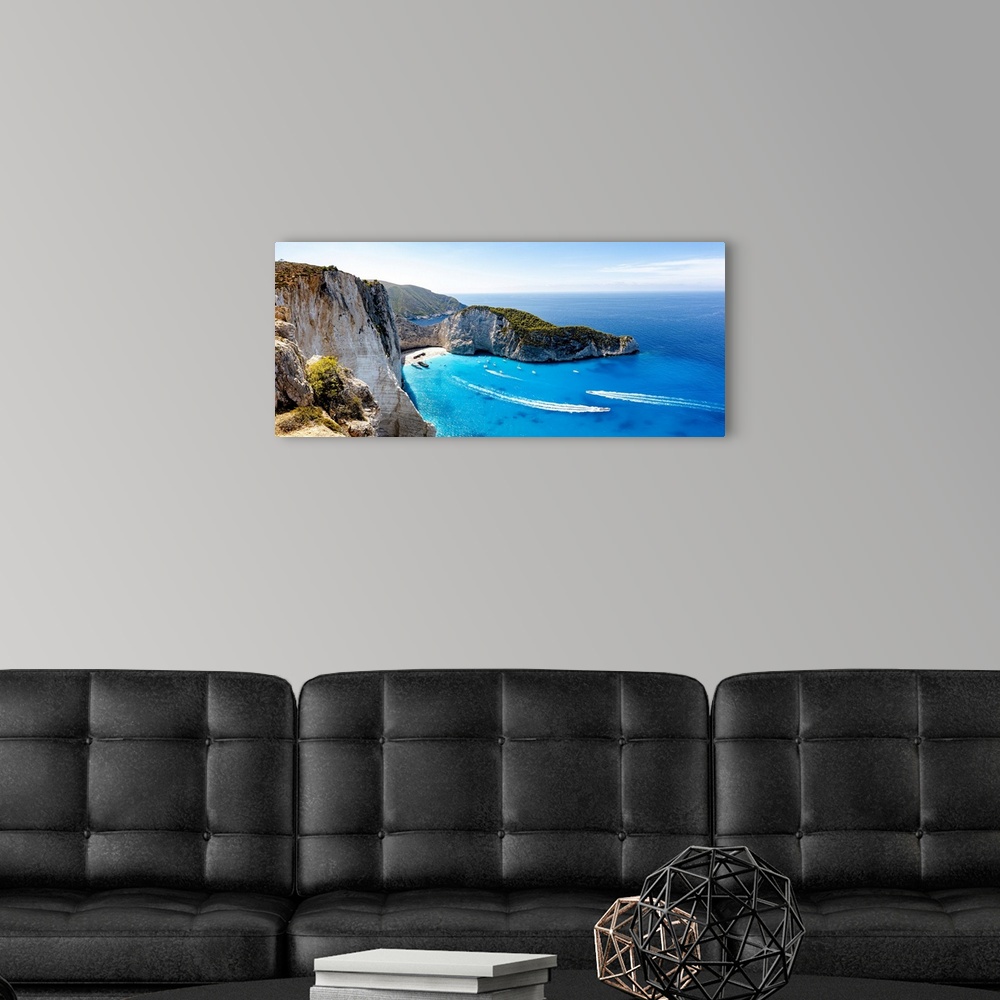 A modern room featuring Ferry boats in the turquoise lagoon surrounding the iconic Shipwreck Beach (Navagio Beach), aeria...