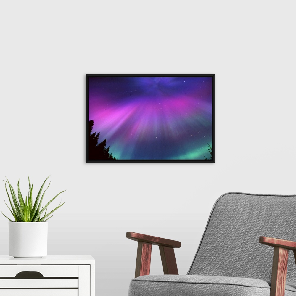 A modern room featuring This landscape photograph captures the glow of the Northern lights and the speckles of stars beyo...