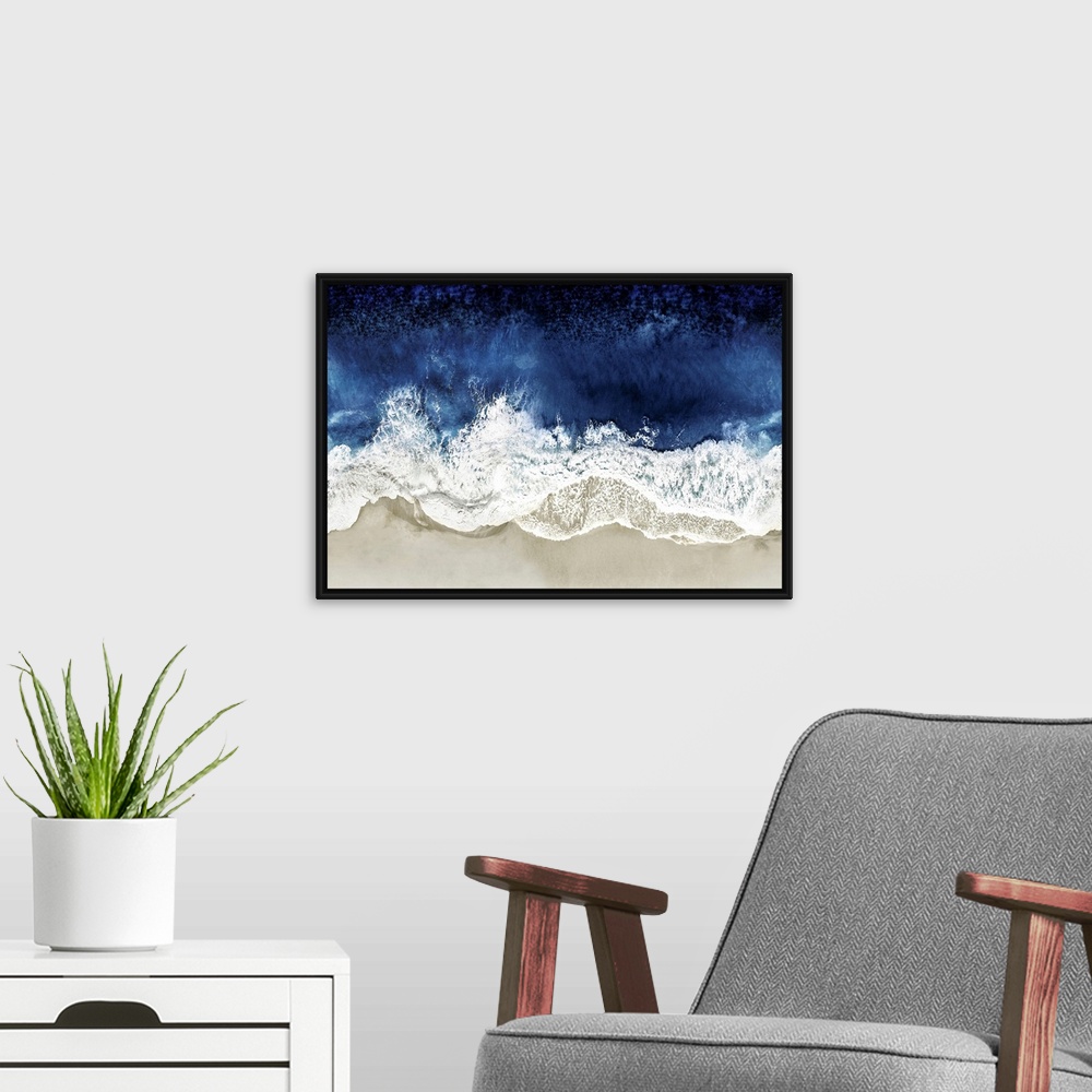 A modern room featuring One artwork in a series of aerial shots of a beach as dark blue waves break upon the shore.