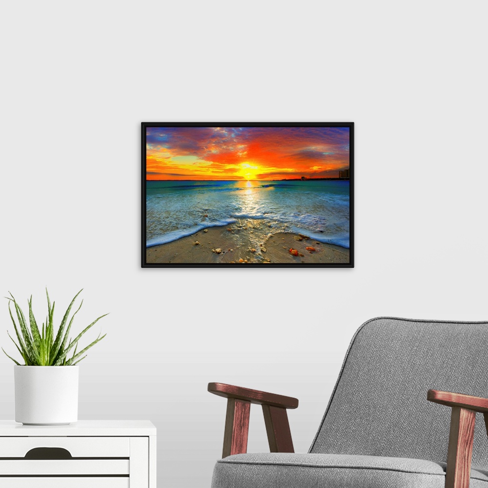 A modern room featuring A dark red ocean sunset at seashore. Gentle blue ocean waves roll over the shore.