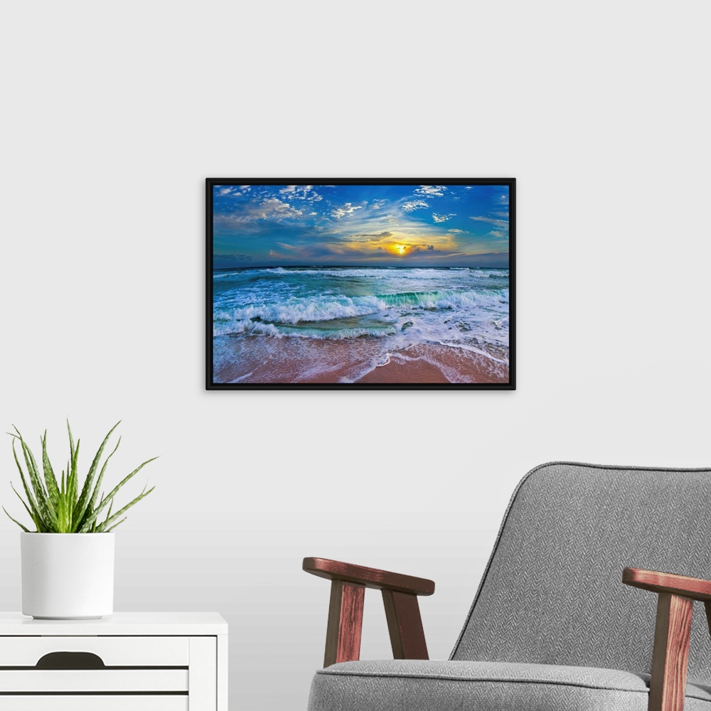 A modern room featuring A glimpse of a yellow sunset within a cold blue sunset. Blue waves hit a tropical sea shore.