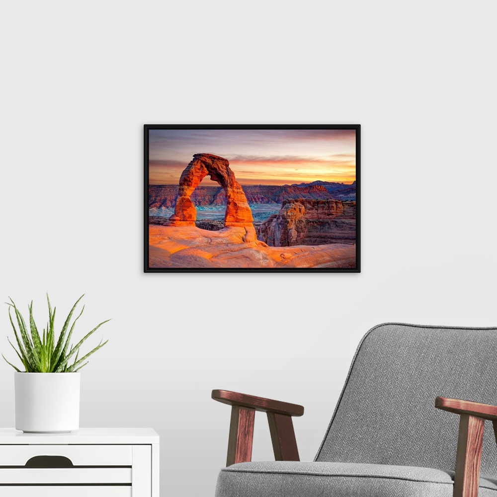 A modern room featuring This wall art for the home or office shows desert rock cliffs growing in the light of a sunset.