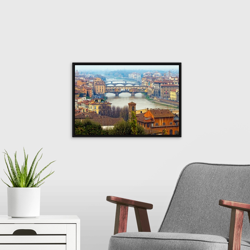 A modern room featuring Giant photograph overlooking the Fiume Arno surrounded by a busy city within Italy.  On the shore...