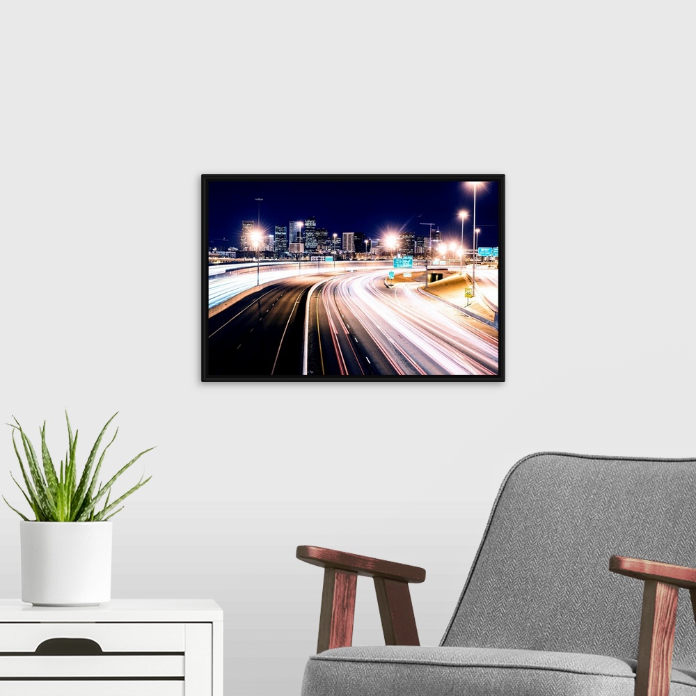 A modern room featuring Photo of light trails against Denver's night skyline.