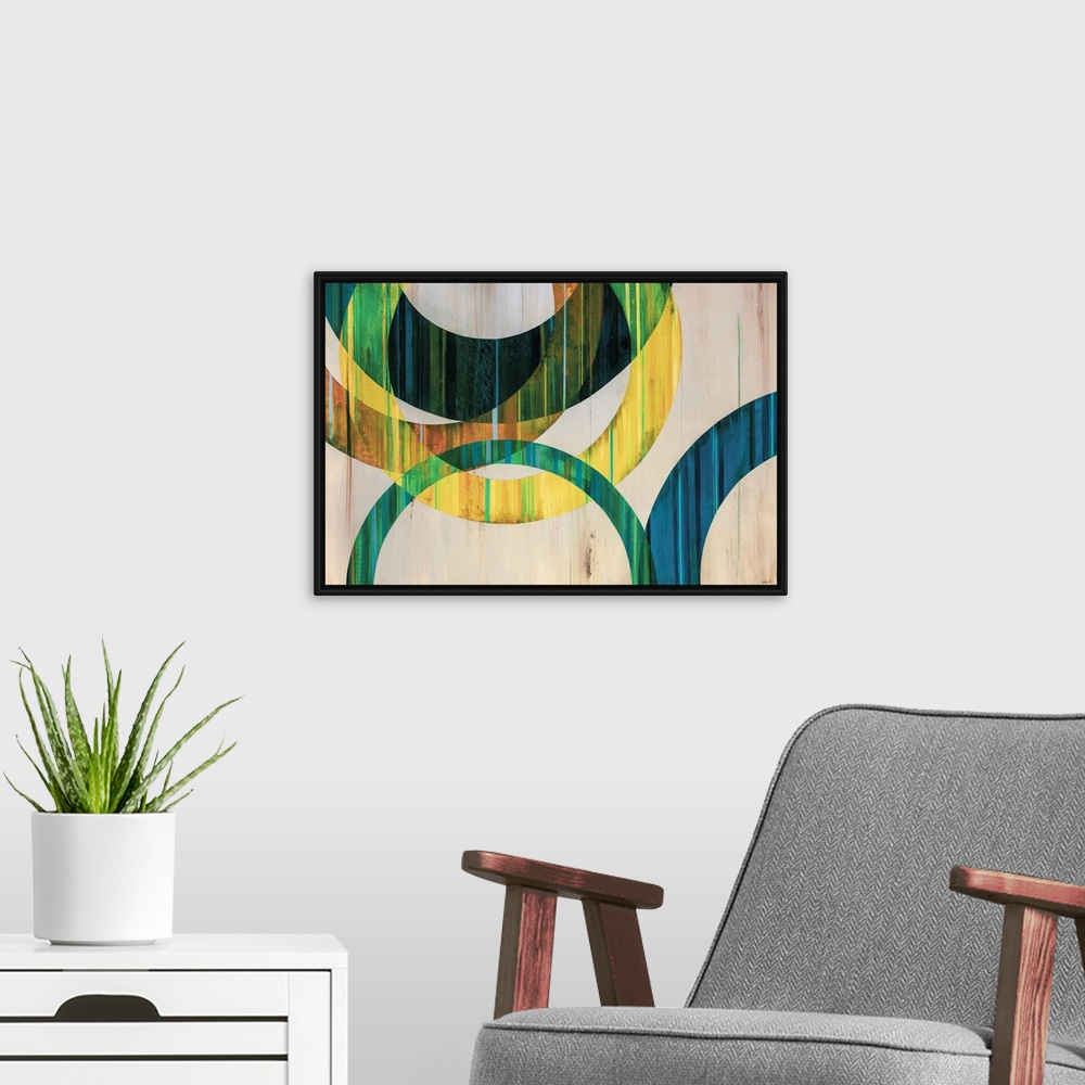 A modern room featuring Modern abstract art of circular rings painting in shades of blue, green, yellow, and orange over ...