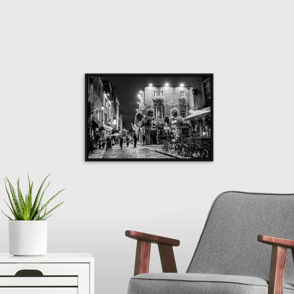 A modern room featuring Photograph of Temple Bar, a busy riverside neighborhood in Dublin, Ireland, at night.