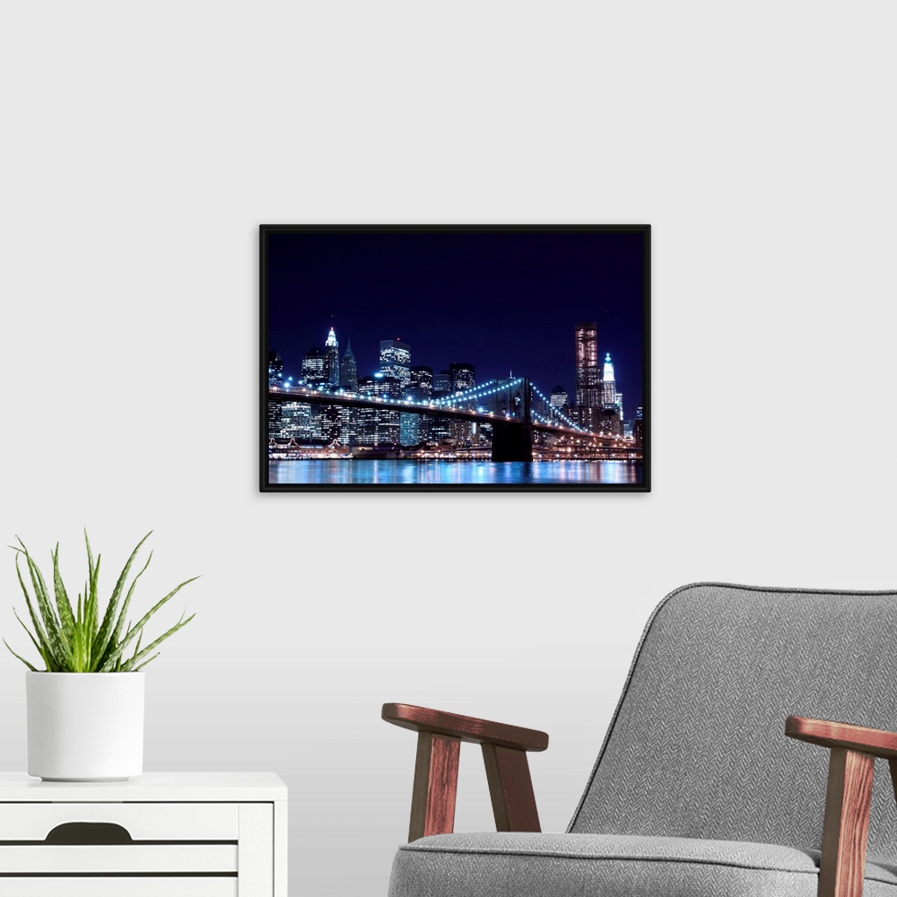 A modern room featuring Brooklyn Bridge and Manhattan Skyline At Night, New York City.
