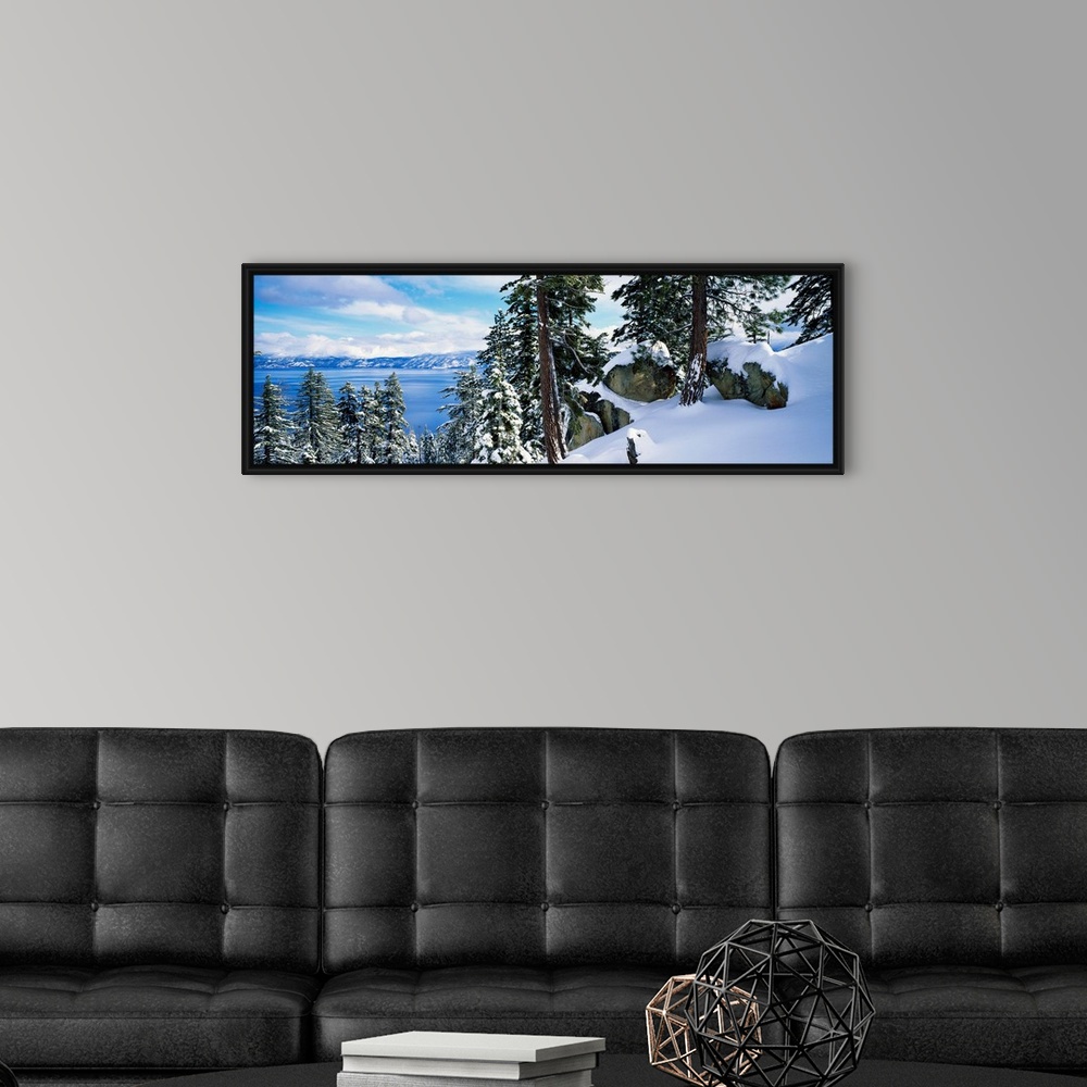 A modern room featuring A landscape photograph taken from a mountain ridge in winter looking down into the scenic lake an...