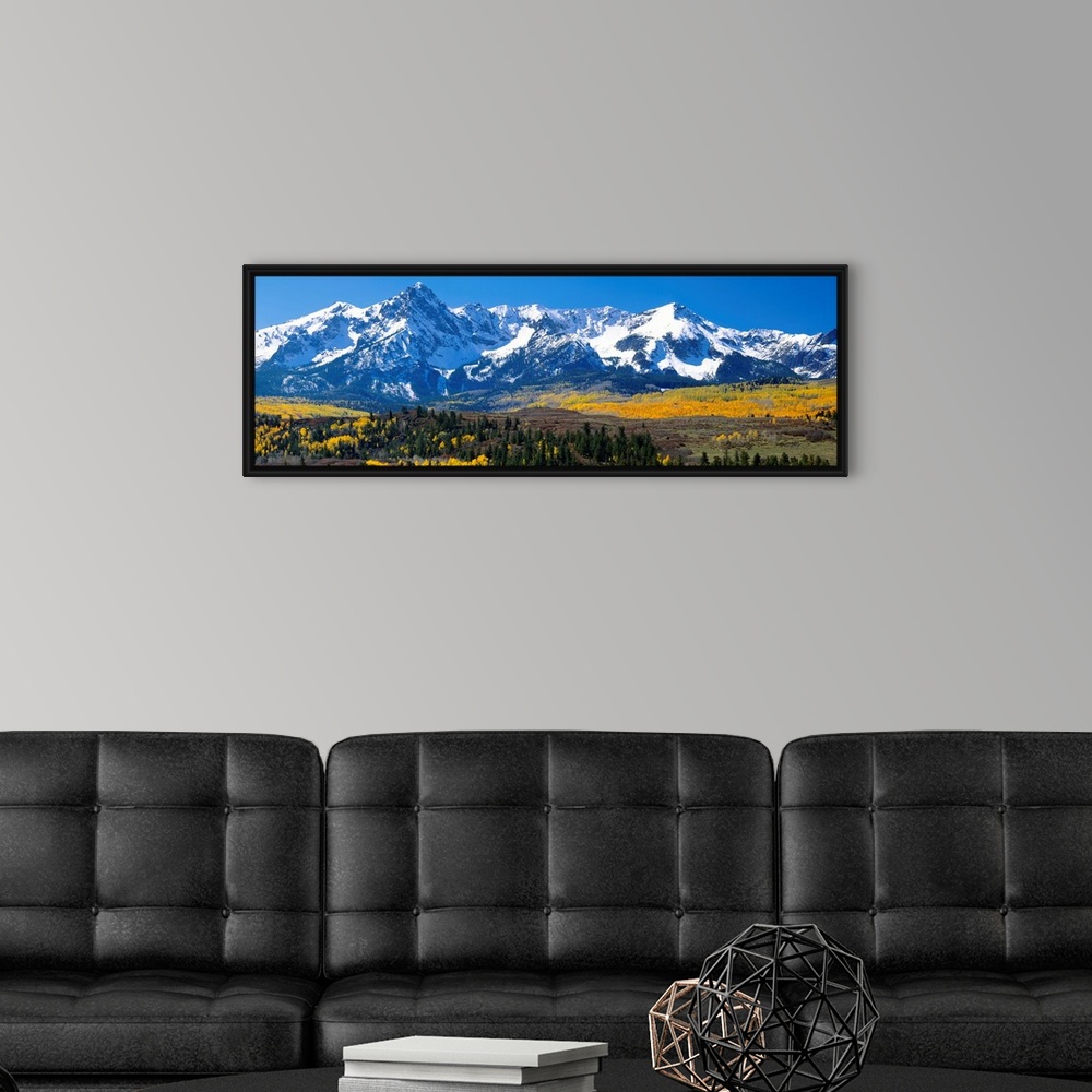 A modern room featuring Panoramic image of a wilderness area at the base of a snowy mountain range.