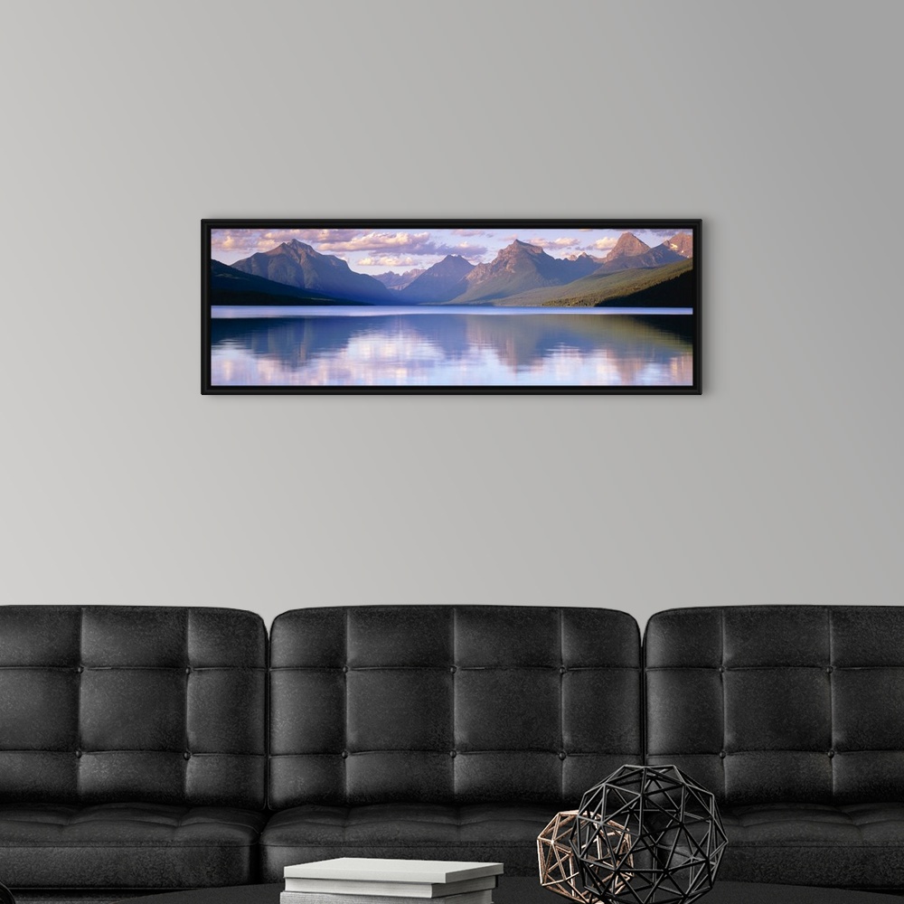 A modern room featuring Oversized, horizontal photograph of mountains reflecting in the calm waters of Lake McDonald in G...