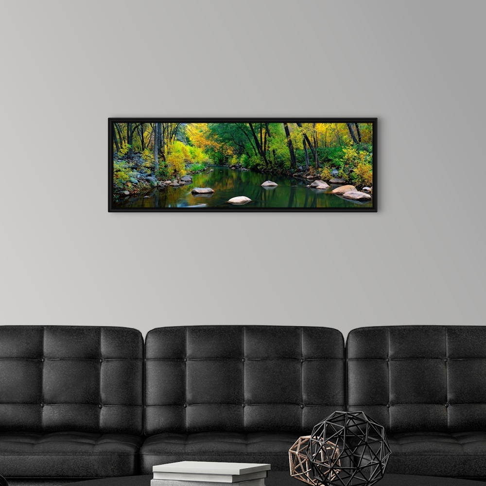 A modern room featuring A calm stream flows through a forest in this panoramic landscape photograph.