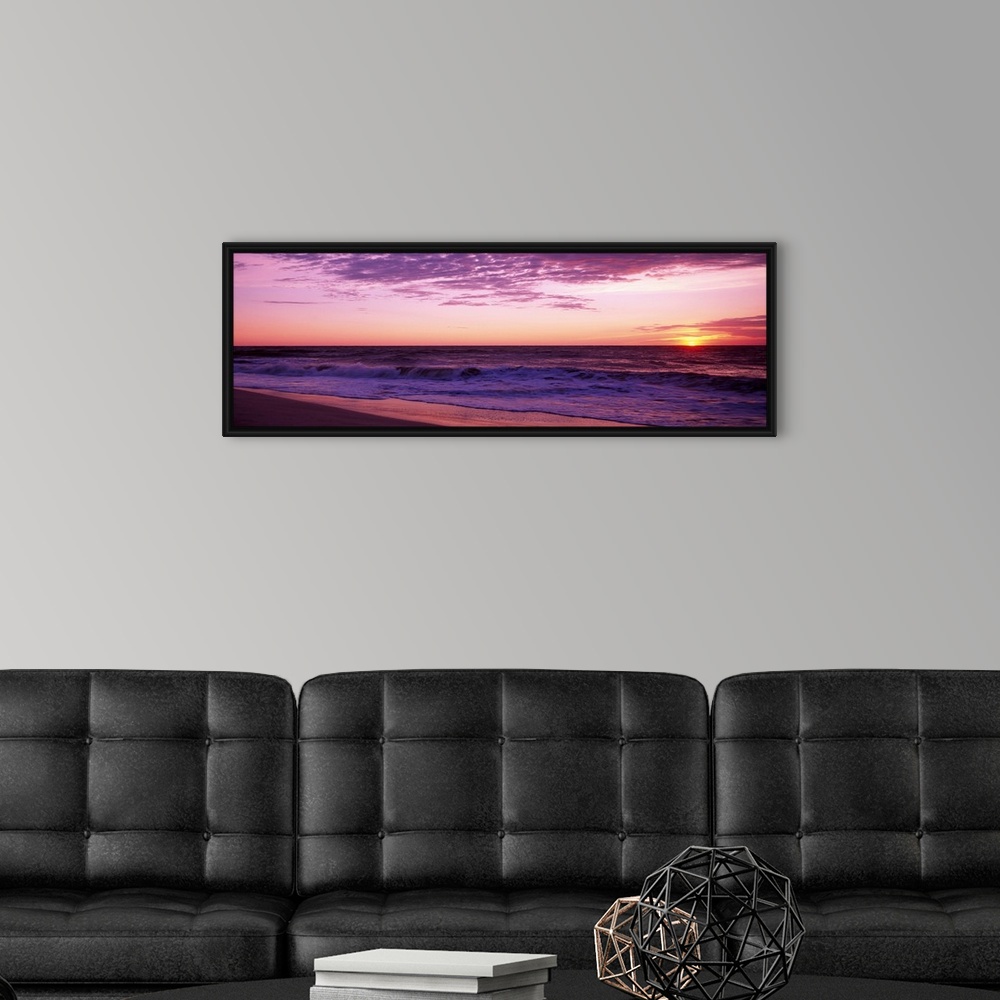 A modern room featuring Small waves washing up on shore as the sunrises in this landscape photograph.