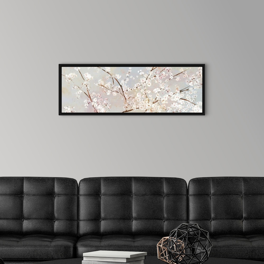 A modern room featuring A long panoramic painting of a large branch of white cherry blossoms.