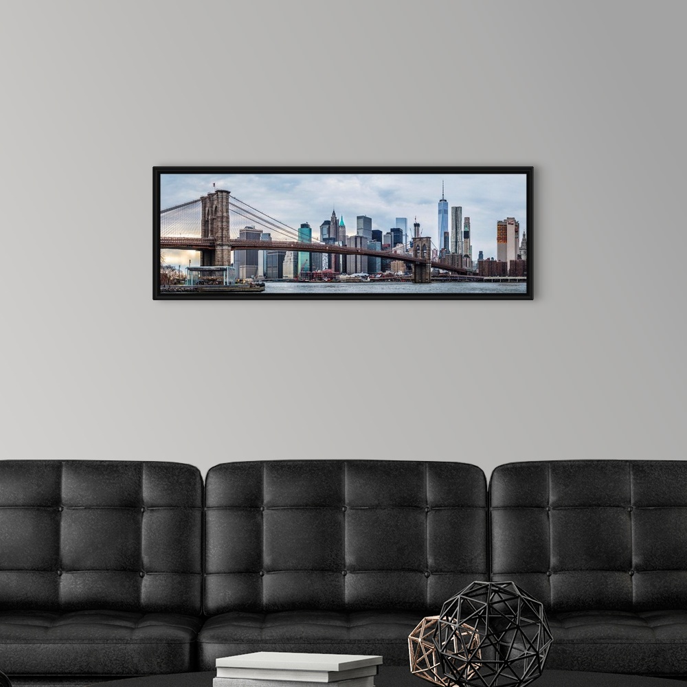 A modern room featuring View of the New York City skyline under an overcast sky, with the Brooklyn Bridge, from across th...