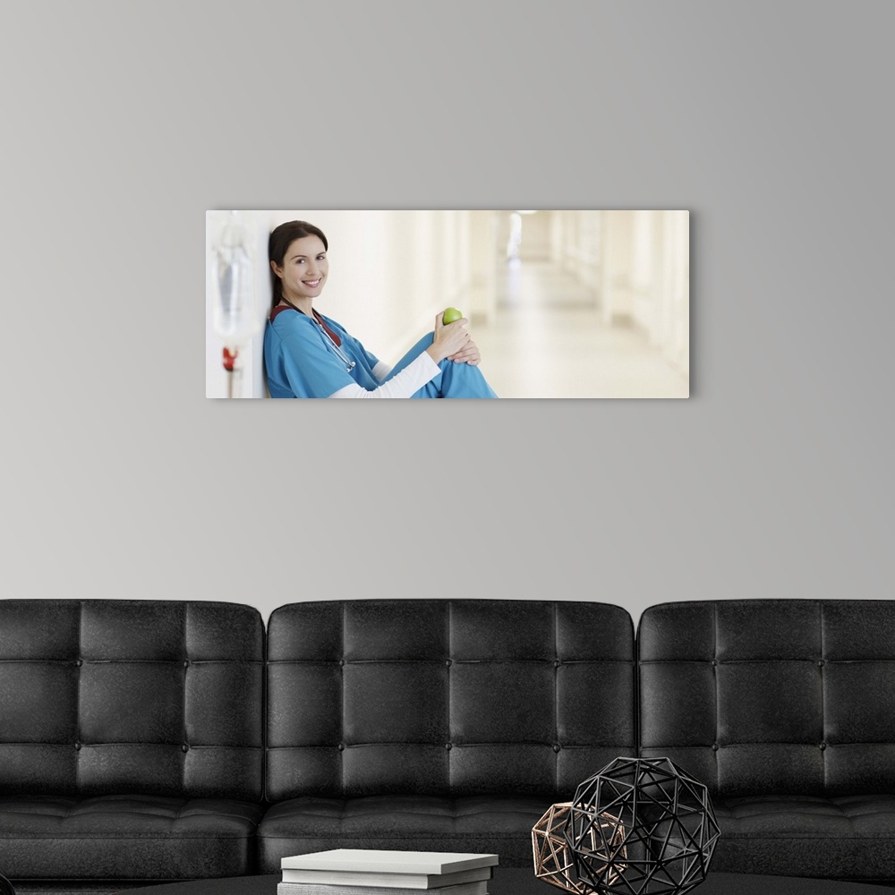 A modern room featuring Nurse sitting with apple in hospital corridor