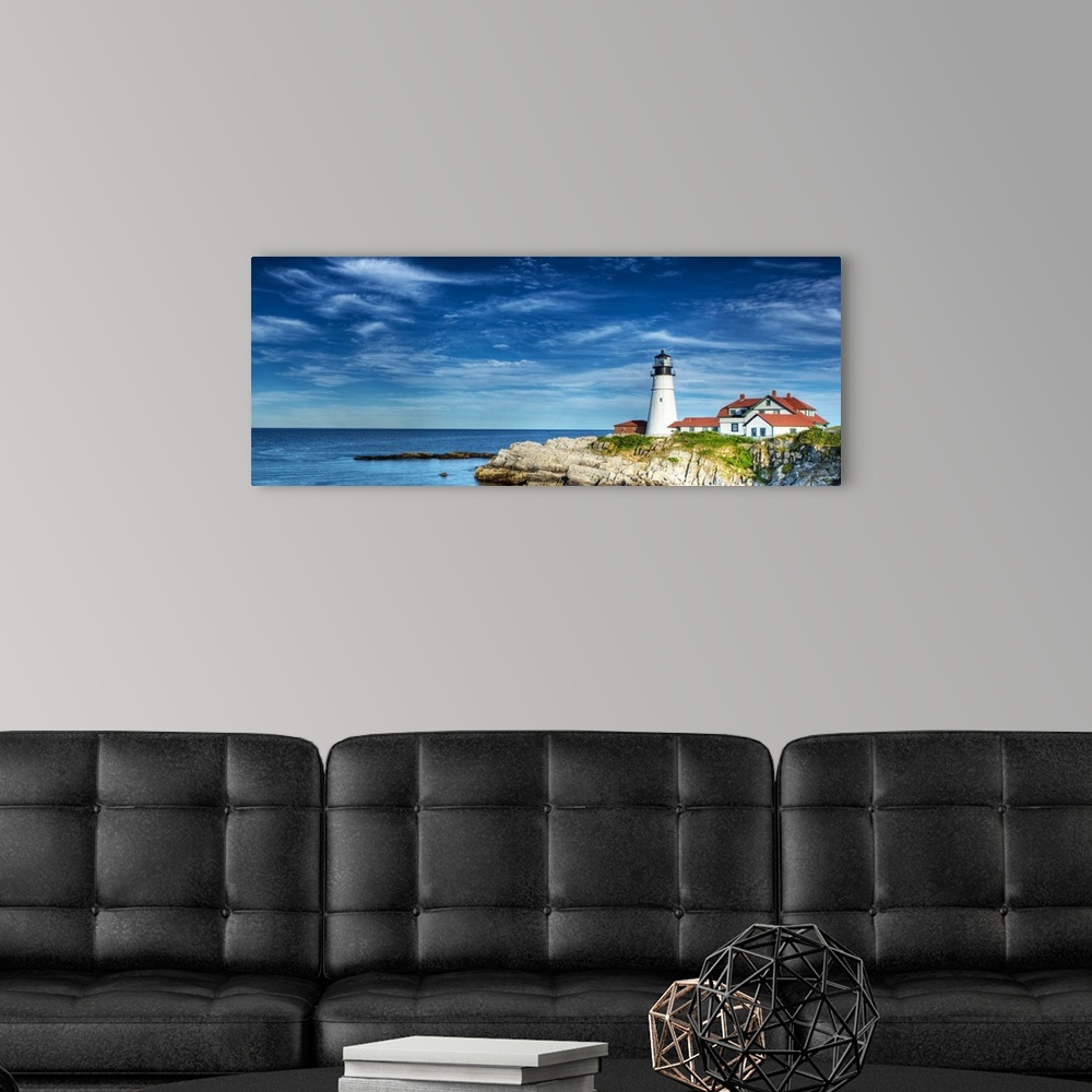 A modern room featuring Photograph of a lighthouse on the rocky shore against a blue sky.