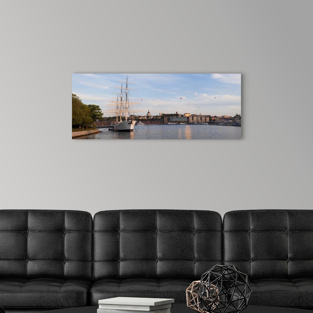 A modern room featuring Schooner at a harbor with a city in the background with Hot Air Balloons in the sky Af Chapman Sk...