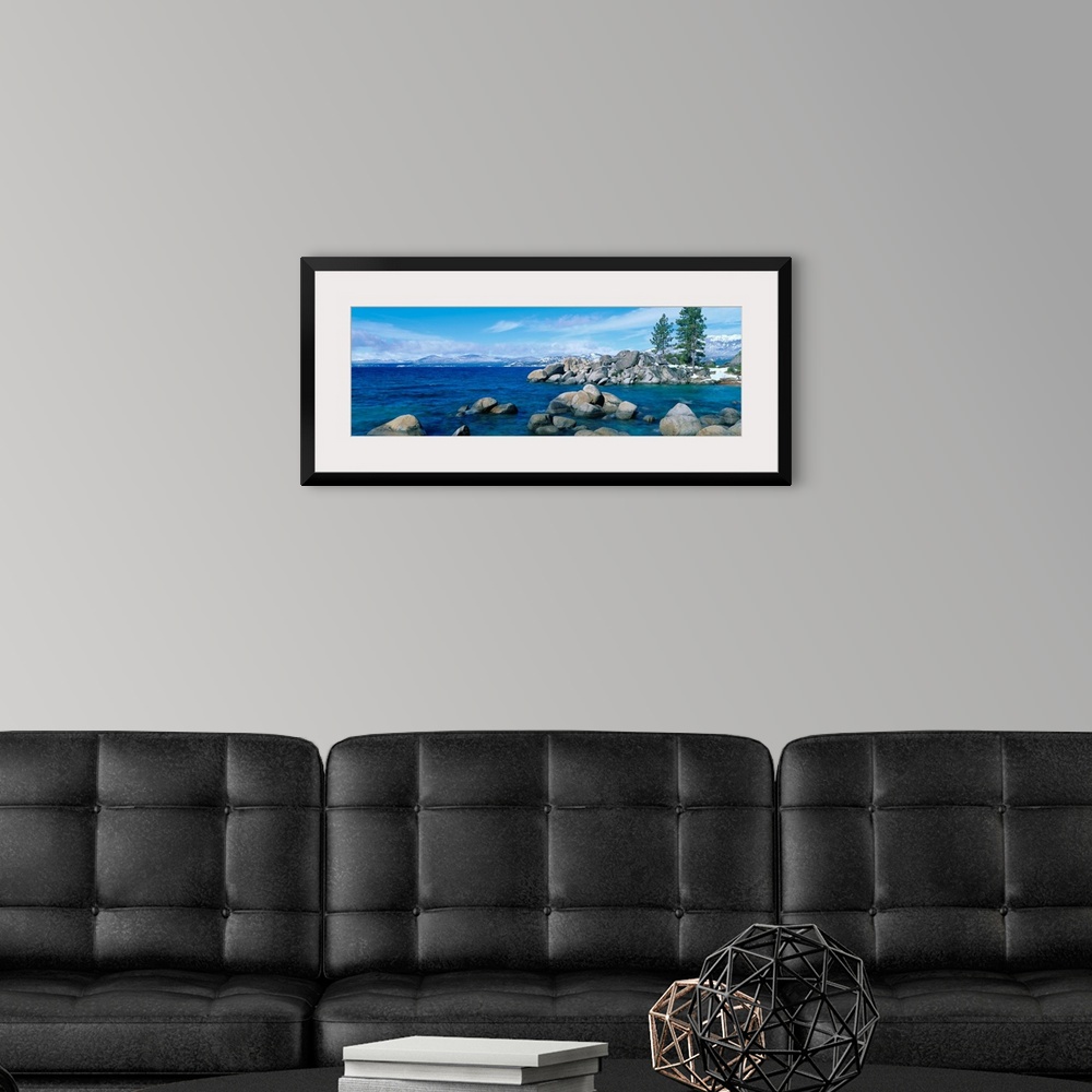 A modern room featuring A panoramic photograph taken at eye level this home wall art shows the boulder covered shores of ...