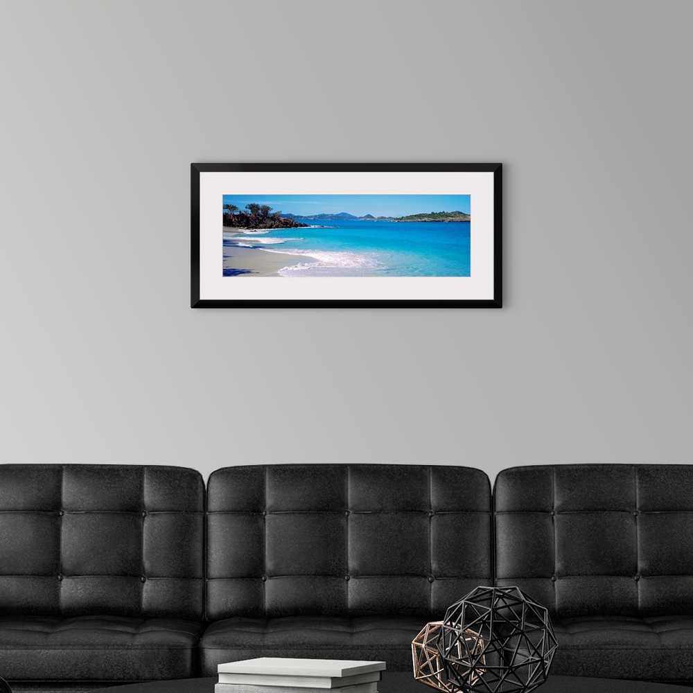 A modern room featuring Panoramic photograph displays the calm waters of this bay slowly crashing into the sandy beach, w...